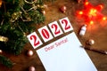 Letter dear santa on a wooden background with the numbers 2021, a blank sheet of paper, covid-19 vaccine, led is a garland, a red Royalty Free Stock Photo