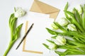 Letter, envelope and tulips on white background. Invitation card, or love letter. Top view, flat lay Royalty Free Stock Photo