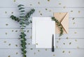 Letter, envelope and eucalyptus branches on grey background. Invitation card, or love letter. Top view, flat lay