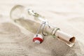 letter in a glass bottle on sea sand. Message written and sent in the distant past. A valuable find on the beach Royalty Free Stock Photo