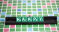 Letter green scrabble is spelling word HAPPY on the rack