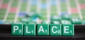 Letter green scrabble is spelling word PLACE.