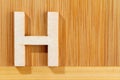 Letter H of wood-made alphabet, top view and space for text