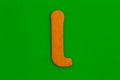 Letter i made of wood painted orange on green background