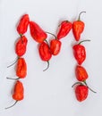 Letter M alphabet made with Ghost pepper Bhoot jolokia over white background