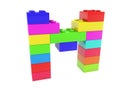 The letter M is composed of toy bricks of different colors on white