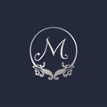 Letter M Decorative Crown Ring Alphabet Logo isolated on Navy Blue Background. Luxury Silver Initial Abjad Logo Design Template.