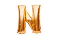 Letter N made of golden inflatable helium balloon isolated on white. Gold foil balloon font part of full alphabet set of upper Royalty Free Stock Photo