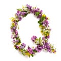 The letter ÃÂ«QÃÂ» made of various natural small flowers.