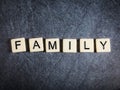 Letter tiles on black slate background spelling Family