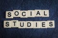 Letter tiles on black slate background spelling Social Studies Royalty Free Stock Photo