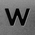 Letter W on a silver grained shiny metal surface. English alphabet.