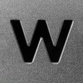Letter W on a silver grained shiny metal surface. English alphabet.
