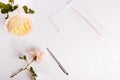 Letter, white envelope on white background with pink english rose. Invitation cards or love letter.