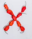 Letter X alphabet made with Ghost pepper Bhoot jolokia over white background