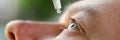 Man putting liquid drops in his eye solving vision problem Royalty Free Stock Photo