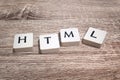 Plastic tiles on wooden board forming the acronym HTML