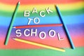 Lettering Back to School with Crayons on the rainbow Background