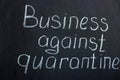 The lettering on the chalk board `Business against quarantine`