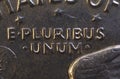 Lettering E Pluribus Unum, one out of many, on the reverse of the one dollar USA coin issued in 1978, isolated on the black