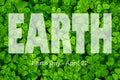 Lettering Earth Day April 22 on the background of clover. Earth day concept, protection of the planet from pollution, improvement