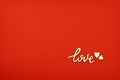 Lettering love and wooden hearts on red paper