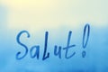 lettering Salut in French is hello in english paint with finger with streaks of water on splashed by rain foggy glass on