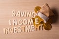 Lettering ` SAVING INCOME INVESTMENT with coins