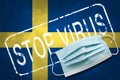 Lettering stamp Stop Virus and medical mask on Sweden flag. Return of the coronavirus. New jump in incidence. Strain Omicron and