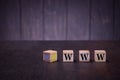 The letters abbreviation www on wooden cubes, on a dark background, light wooden cubes signs Royalty Free Stock Photo