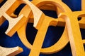 Letters cut out of polystyrene with gold color on a blue background. blank for decoration, logo making. Royalty Free Stock Photo