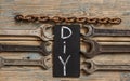 Flat lay with different carpentry tools set of hand tools and letters of DIY on a wooden background. Old rusty tools Royalty Free Stock Photo