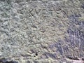 Letters engraved by vandals into sandstone rock