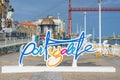 Letters identifying the city of Portucalete, in the background the Biscay bridge over the NerviÃ³n river. Portugalete