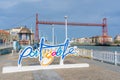 Letters identifying the city of Portucalete, in the background the Biscay bridge over the NerviÃ³n river.  Portugalete Royalty Free Stock Photo
