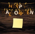 The letters and the inscription of a happy Halloween hang on clothespins on a rope or string. Vector on wooden back. Yellow sheet