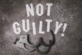 Letters with the inscription - Not guilty. Social concept with open handcuffs Royalty Free Stock Photo