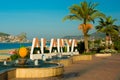 Letters of the name of the city of Alanya and a fountain with a sculpture of apricot fruit. Landscape with a view of the city. Royalty Free Stock Photo