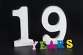 Letters and numbers nineteen years old on a black background. Royalty Free Stock Photo
