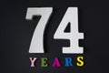 Letters and numbers seventy-four years on a black background. Royalty Free Stock Photo