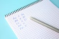 Letters and numbers written in notepad with erasable pen on light blue background, closeup