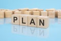 letters Plan made with wood building blocks. blue background. business concept