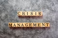 The letters on the wooden blocks that write the word crisis management on the black background