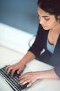 Letting her fingers do the talking. High angle shot of an attractive young businesswoman working on a laptop in her