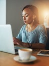 Letting her fingers do the talking. a young woman using her laptop while working late in her office.