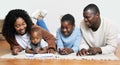 Letting his creativity run wild. a two young parents lying on the living room floor with their children and watching Royalty Free Stock Photo