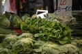 Selective blur on green lettuce salads for sale on Zeleni Venac market in Belgrade, Serbia with their price displayed.