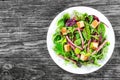 delicious fresh salad of salami and mixed lettuce leaves - baby spinach, arugula, chard in a white dish on the old wooden Royalty Free Stock Photo