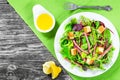 delicious fresh salad of salami and mixed lettuce leaves - baby spinach, arugula, chard in a white dish on the old wooden Royalty Free Stock Photo