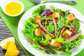 delicious fresh salad of salami and mixed lettuce leaves - baby spinach, arugula, chard in a white dish on the old wooden Royalty Free Stock Photo